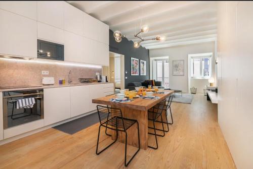 a large kitchen with a wooden table and chairs at WHome | LS48 Prime Location Upscale Family Apartment in Lisbon