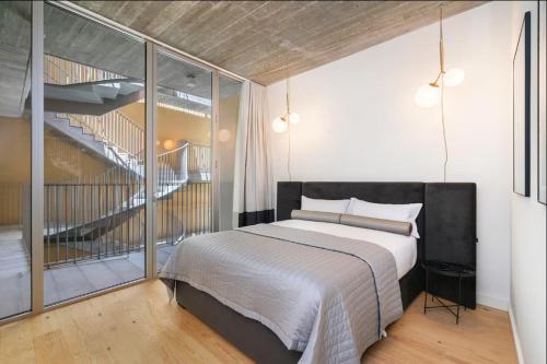 a bedroom with a large bed and a staircase at WHome | LS48 Prime Location Upscale Family Apartment in Lisbon
