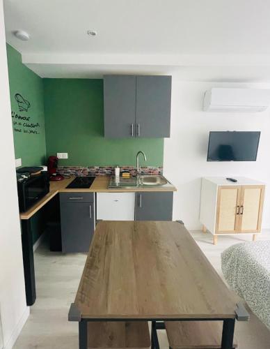 - une cuisine avec une table en bois dans une chambre dans l'établissement Éclat St Romain 2, studio-moderne-WIFI- parking - CLIM, à Saint-Romain-en-Gal