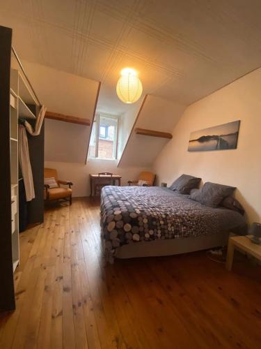 une chambre avec un grand lit dans un grenier dans l'établissement Maison charmante à Saint-Valery-en-Caux avec jardin clos, à Saint-Valery-en-Caux