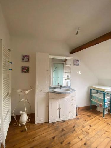 La salle de bains est pourvue d'un lavabo et d'une table. dans l'établissement Maison charmante à Saint-Valery-en-Caux avec jardin clos, à Saint-Valery-en-Caux