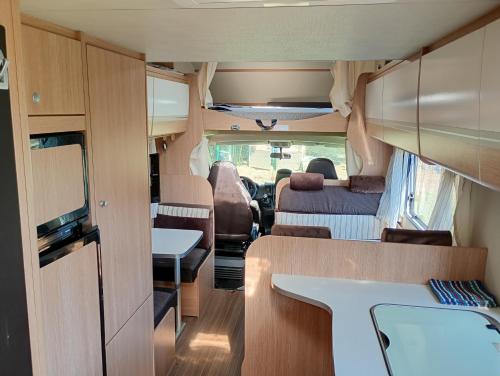 Cette chambre offre une vue sur l'intérieur d'un parc avec une table et des chaises. dans l'établissement Camping car au bord de l eau, à Pujo-le-Plan