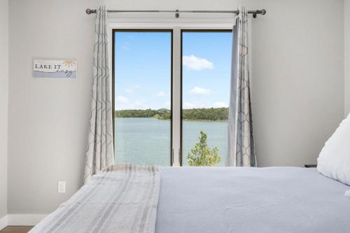 a bedroom with a large window with a view of the water at Table Rock Shoreline Steps Away, Newly Renovated Condo, $400 of Daily Free Tickets in Kimberling City