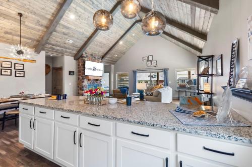 a kitchen with white cabinets and a large island at New Log Cabin, Free Local Attraction Tickets Daily, Ozark Views, Cmty Amenities! in Branson
