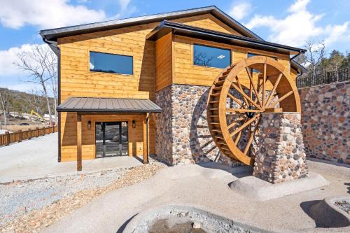 a wooden cabin with a large wheel in front of it at Multiple Arcades-Private Hot Tub-Cmty Indoor Pool-Free Daily Tickets-Water View-Cmty Dog Park in Hollister