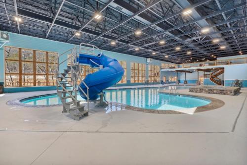 a swimming pool with a blue slide in a building at Multiple Arcades-Private Hot Tub-Cmty Indoor Pool-Free Daily Tickets-Water View-Cmty Dog Park in Hollister