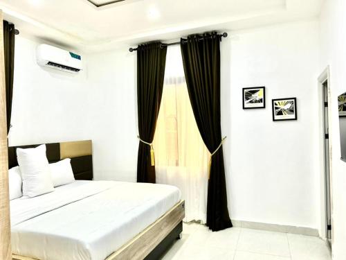 Benin CityにあるVIN-RUES Apartment and Suitesのベッドと窓のある寝室