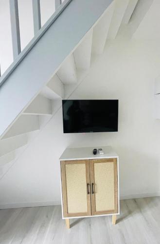 - un salon sous les escaliers doté d'une télévision dans l'établissement Éclat St Romain n3, duplex - moderne - WIFI - CLIM- proche Vienne, à Saint-Romain-en-Gal