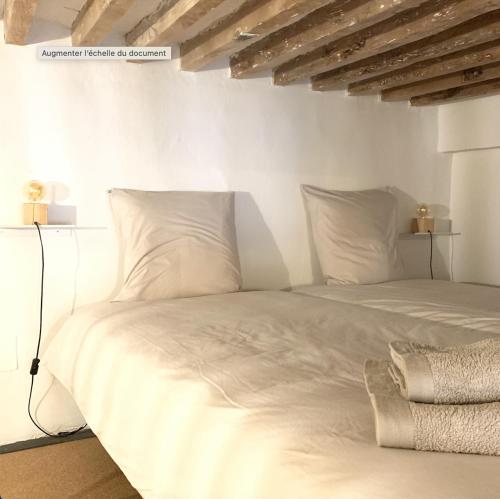 un lit blanc avec des draps et des oreillers blancs dans l'établissement Superbe appartement - 10 min plage - Parking, à La Ciotat