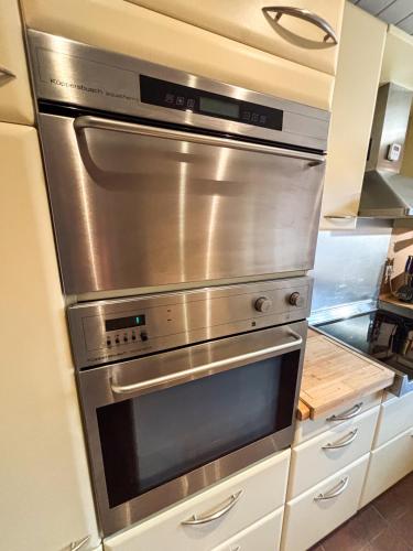 a stainless steel oven in a kitchen at Le Green Field Lodge - Parking Gratuit - Standing - Centre Ville - Commerces à Proximité in Lingolsheim