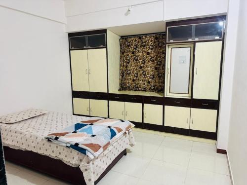 a bedroom with a bed and cabinets and a window at Siddhi Row House -2 BHK Bungalow in Nashik
