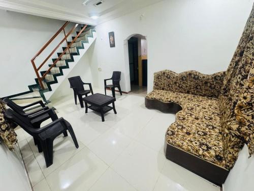 a living room with a couch and chairs and a staircase at Siddhi Row House -2 BHK Bungalow in Nashik