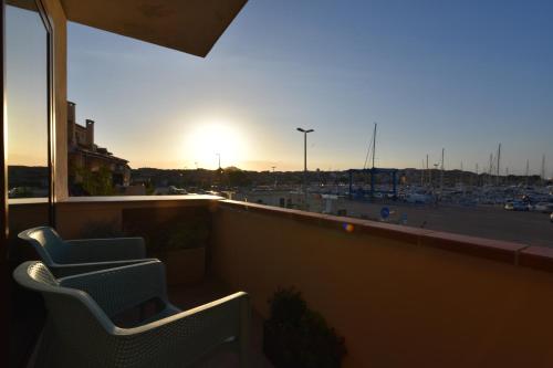 a balcony with two chairs and a view of a parking lot at Fronte mare Palau, porto turistico e spiaggia in Palau