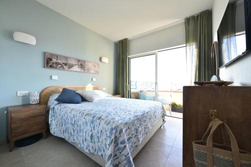 a bedroom with a bed and a large window at Fronte mare Palau, porto turistico e spiaggia in Palau