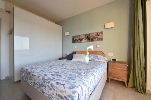 a bedroom with a bed with a blue comforter at Fronte mare Palau, porto turistico e spiaggia in Palau