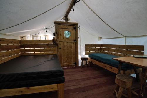 a room with a bed and a table in a tent at Les Toits Du Monde in Nominingue