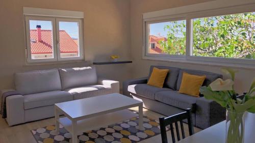 a living room with couches and a table and two windows at Spacious House with Private Pool Kitchen in Teixoso