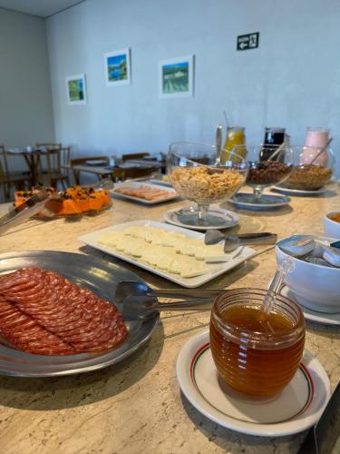 カンポス・ド・ジョルドンにあるMoinho Itália Hotelのチーズなどの食べ物を載せたテーブル