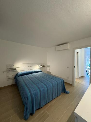 a bedroom with a large bed with a blue blanket at Porto San Paolo Nature Apartment in Porto San Paolo