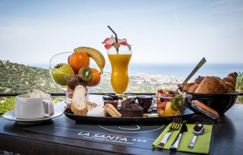 ein Tablett mit Essen auf einem Tisch und einem Getränk in der Unterkunft Hotel La Santa in Santa-Reparata-di-Balagna