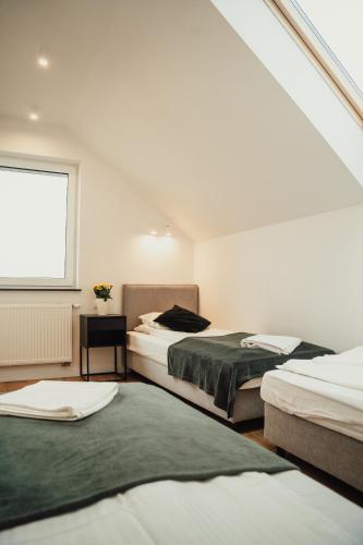 a bedroom with two beds and a window at Apartamenty Nad Wodą in Chmielno