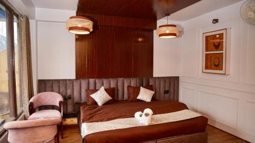 a bedroom with a bed and a chair at HOTEL NIRVANA in Kalpa