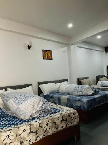 a room with two beds with pillows on them at Satyam Shivam Sundaram in Mukteswar
