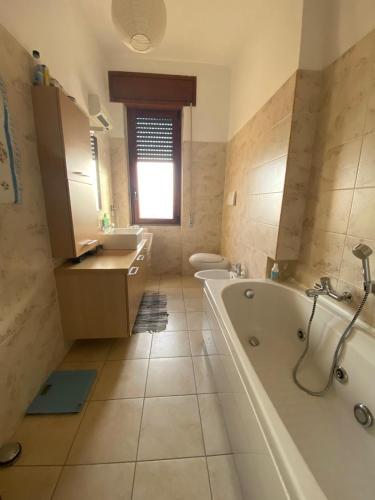 une salle de bain avec une baignoire, des toilettes et un lavabo dans l'établissement Appartamento Luminoso a Carbonia (I.U.N. Q8271), à Carbonia