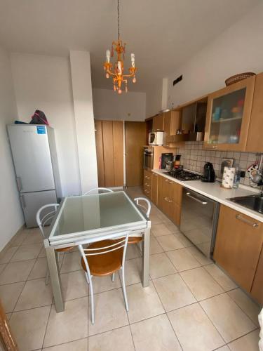 une cuisine avec une table, des chaises et un réfrigérateur dans l'établissement Appartamento Luminoso a Carbonia (I.U.N. Q8271), à Carbonia