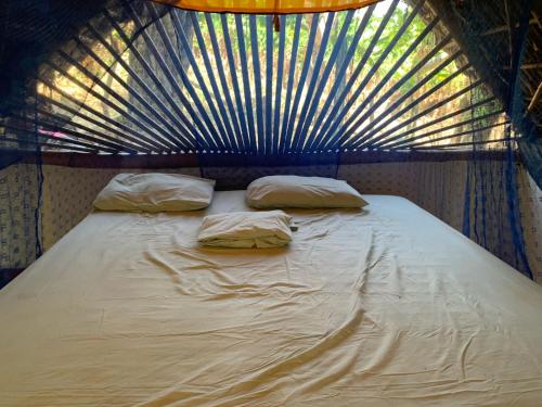 a large bed with two pillows on top of it at El Zopilote in Balgue