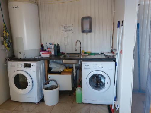 a kitchen with a washing machine and a sink at Ásbrandsstadir Cottages in Vopnafjörður