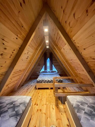 a room with two beds in a wooden attic at Eco resort Komarnica in Šavnik