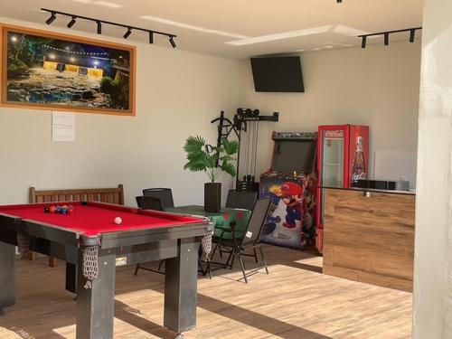 a living room with a pool table and a video game at Espaço Alvorada com Banheira ,agendamento das atividades, café da manhã no centro in Brotas