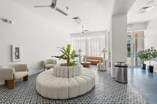 a lobby with a large white waiting room with a plant at Global Luxury Suites at The Apex Miami in Miami Beach
