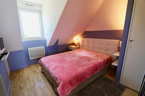 une chambre avec un lit avec une couverture rose dans l'établissement Cozy apartment with exceptional sea view - CANCALE, à Cancale
