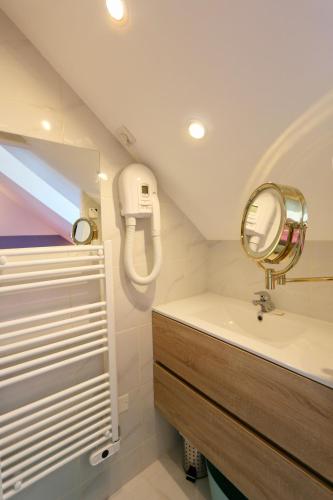 une salle de bain avec un lavabo et un miroir dans l'établissement Cozy apartment with exceptional sea view - CANCALE, à Cancale