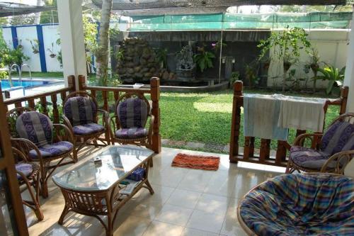 een veranda met stoelen, een tafel en een aquarium bij Orchid Villa in Negombo