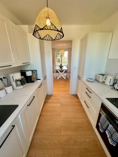 a kitchen with white cabinets and a chandelier at Cœur de St Tropez in Saint-Tropez
