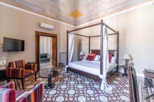 a bedroom with a canopy bed and a living room at Vittorio's in Bari