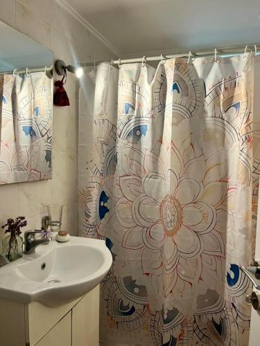 a bathroom with a shower curtain with a sink at Evita Studios in Xiropigado