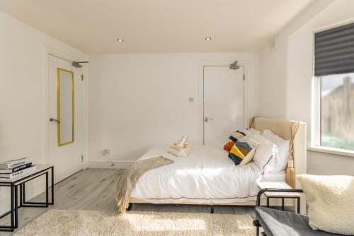 a white bedroom with a bed and a window at Luxury Studio with Free Parking in Nottingham