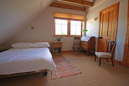 una camera con letto, scrivania e finestra di Netherton Farm B&B a Culbokie