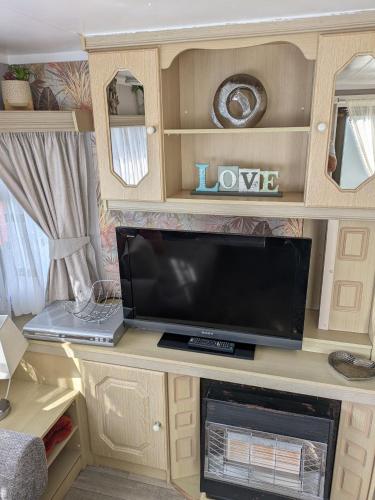 a desk with a tv and a laptop on it at L&g caravan hire 4 BERTH CORAL BEACH GEN FAMILYS ONLY AND LEAD PERSON MUST BE OVER 30 in Ingoldmells