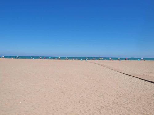 a sandy beach with umbrellas and the ocean at ApartUP Patacona Iconic II in Valencia
