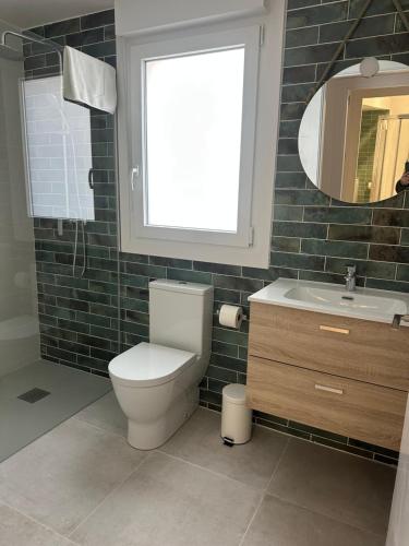 a bathroom with a toilet and a sink and a window at Apartamentos COVARRUBIAS in Covarrubias