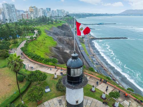 a lighthouse with a flag on it next to the ocean at Sonesta Hotel El Olivar in Lima