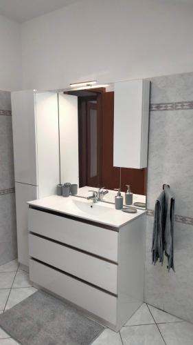 a white bathroom with a sink and a mirror at Corte Cacciatori in Borgosesia
