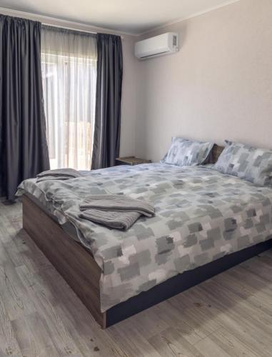 a bedroom with a camo bed with a window at Къщи за гости "Ямира" in Banya