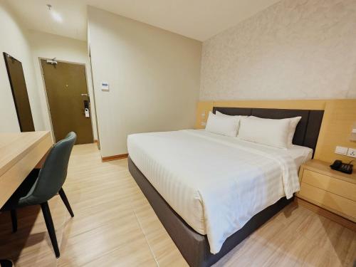 a hotel room with a large bed and a desk at Forum Hotel Penang in George Town
