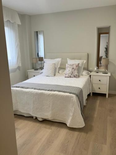 a bedroom with a large white bed with pillows at Apartamento Boutique Arquera Golf III in Llanes